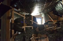 Abigail DeVille, XXXXXXX, 2013, reclaimed lumber, accumulated debris, plastic tarps, tar paper, dirt, sand from Lake Michigan, skeleton, dimensions variable.