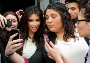 Mal Fairclough/AP -  In a photo from Sept. 21, 2012 , Kim Kardashian, left, is surrounded by her fans who are attempting to have their photographs taken with her as she leaves a radio station in Melbourne, Australia. (Image via Washington Post)